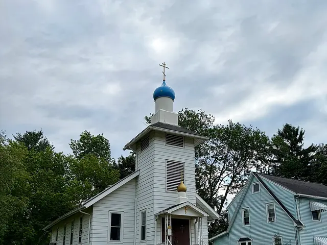 Exterior of St. Nicholas Orthodox Church in Endicott, New York, a white wooden church with a blue and gold onion dome bell tower.