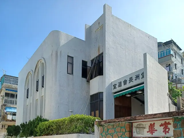 White multi-storey Alliance Church building with arched windows and a rooftop cross on Cheung Chau island, Hong Kong.