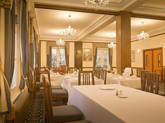 The dining room of the Athenaeum Club in Liverpool, England, set with tables and chairs.