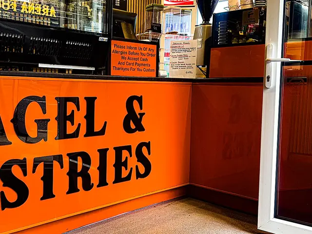 The interior counter and signage of a bagel and pastry shop.