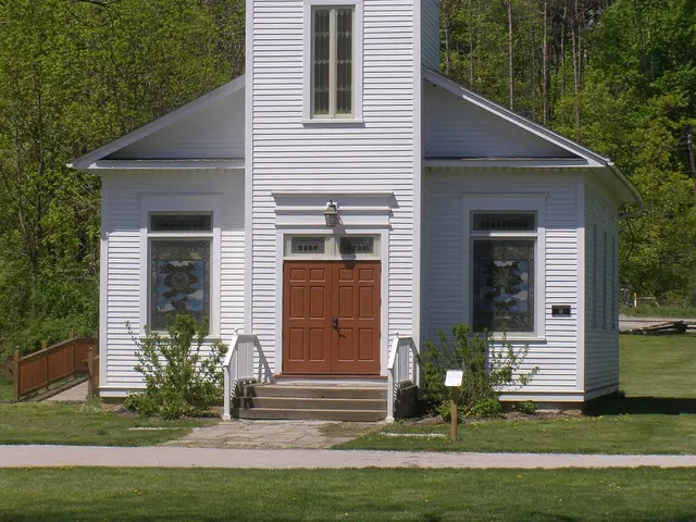 The exterior of a small white wooden village church with a steeple, built in 1847.
