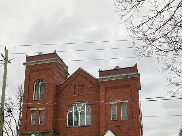 Red-brick Calvary United Church with twin towers and a large arched stained-glass window in London, Ontario.
