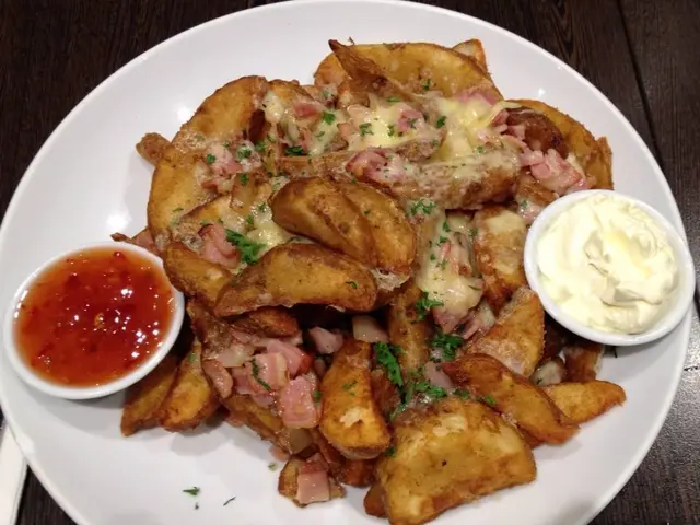 Potato wedges topped with cheese and bacon, served with dipping sauces.