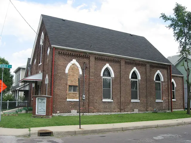 Red-brick former church building with pointed Gothic-arch windows, now home to a small independent congregation in Indianapolis.