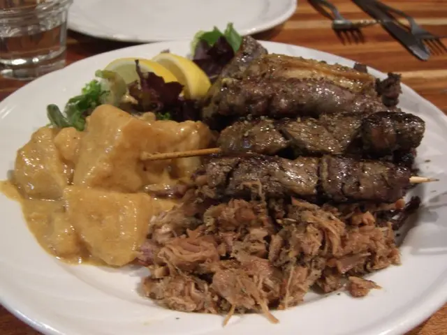 A grilled meat platter with lamb, chicken and potatoes at a Greek tavern.