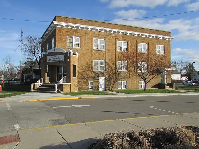 Exterior of Calvary Baptist Church, a two-storey brick building on a street corner, in Nappanee, Indiana.