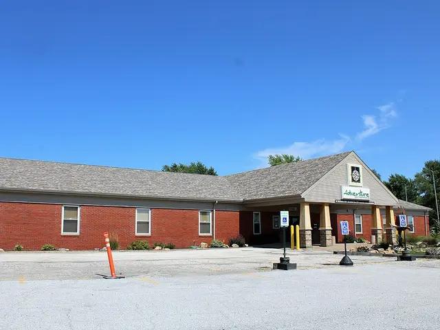 Long single-storey brick Christian church building with a gabled entrance sign reading Adventure, under a clear blue sky