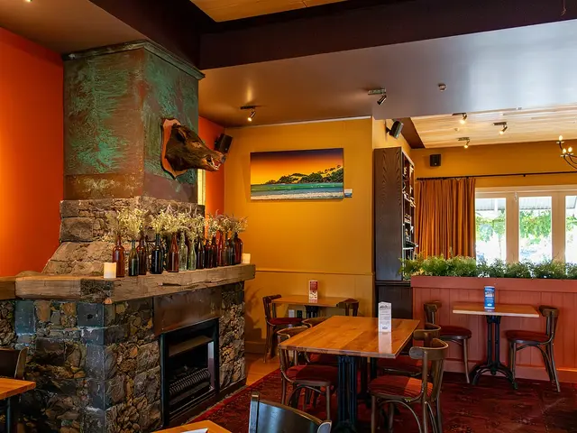 Restaurant seating arranged around a fireplace at The Riverhead in Riverhead, New Zealand.