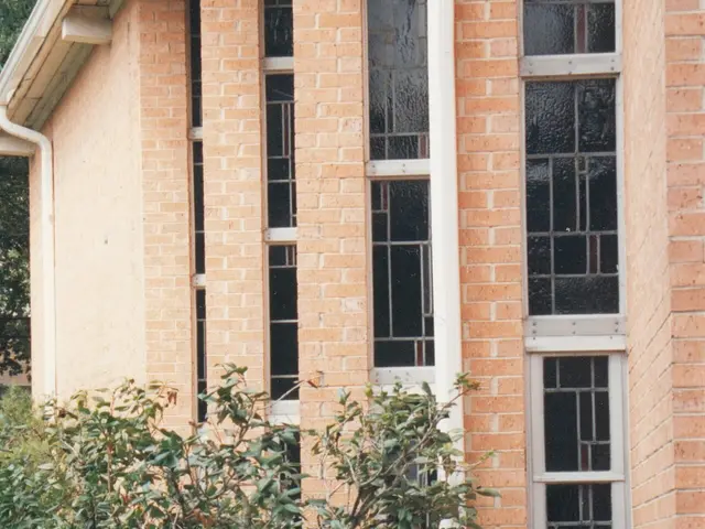 Close exterior view of the Chinese Presbyterian Church of New Orleans building, showing its stained-glass windows and brick facade.