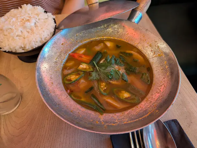 A bowl of tom yum soup with mushrooms.
