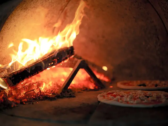 A pizza baking inside a wood-fired brick oven.