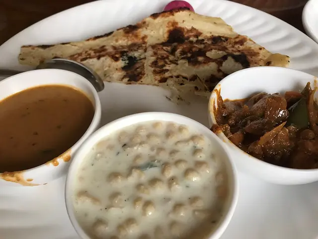 A North Indian vegetarian thali with several small dishes arranged on a metal plate.