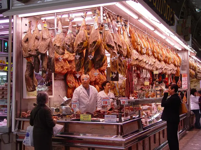 Interior of a butcher shop in Valencia, Spain, with meat displayed at the counter.