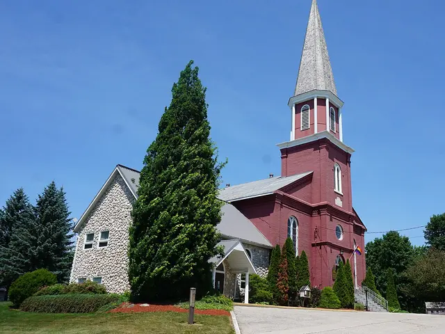 Exterior of Knox United Church, a red brick church building with a tall spire in Embro, Ontario.